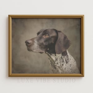 May include: Framed portrait of a German Shorthaired Pointer dog. The dog has a brown head and ears, with a speckled white and brown body. The portrait is in a gold frame. The text "LUXE VIBE STUDIO" is at the bottom.