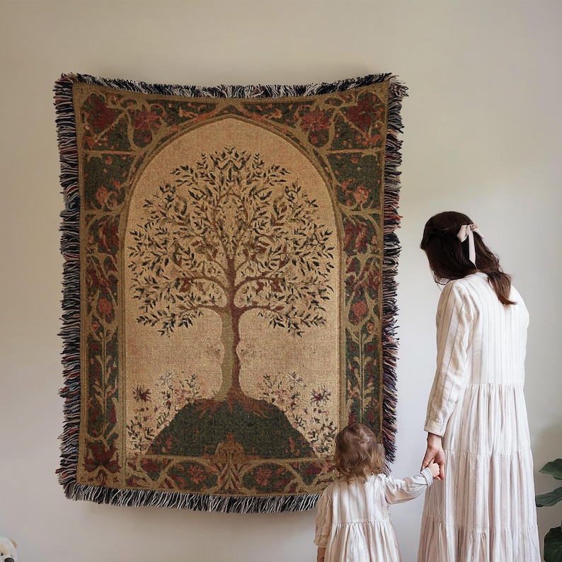 Peut inclure: Une tapisserie avec un motif d'arbre d&eacute;taill&eacute; sur fond beige, encadr&eacute;e d'une bordure d&eacute;corative verte et rouge. La tapisserie a une bordure &agrave; franges. Une femme et un enfant se tiennent &agrave; c&ocirc;t&eacute; de la tapisserie.