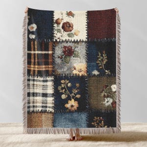 May include: A patchwork throw blanket featuring a variety of floral and plaid patterns in shades of blue, brown, and cream. The blanket has a fringed edge and is made of a soft, woven material. The squares are stitched together with a contrasting thread.