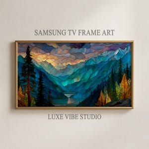 May include: A framed landscape art print for a Samsung TV. The artwork depicts a mountain scene with a lake, rendered in shades of blue, green, and gold. The frame is gold, and the text "SAMSUNG TV FRAME ART" and "LUXE VIBE STUDIO" are visible.