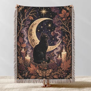 May include: A woven throw blanket featuring a black cat sitting before a large crescent moon, surrounded by lit candles, autumn leaves, branches, and a moth. The design includes a starry night sky and a decorative fringe along the top and bottom edges.