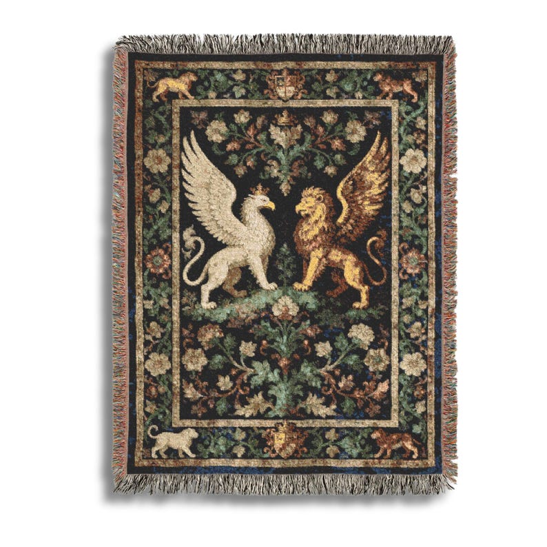 May include: Woven tapestry throw blanket featuring a central design of a winged griffin and a winged lion facing each other. The background is dark with floral and foliage patterns. The blanket has a fringed edge and a decorative border.