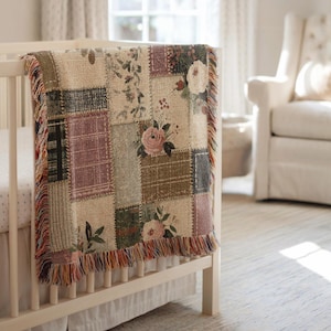 Puede incluir: Una manta de bebé de patchwork con diseños florales y a cuadros en tonos suaves de beige, rosa, verde y marrón. La manta tiene un borde con flecos y está sobre una cuna blanca. El tema general es una guardería vintage y acogedora.