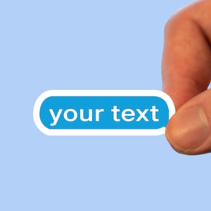 May include: A hand holds a blue sticker with white rounded edges and the text "your text" in white.