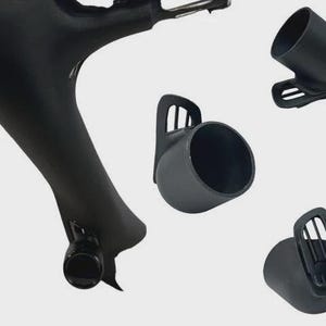 May include: A matte black bicycle frame component featuring a cylindrical mount for accessories. Three additional separate black cylindrical mounts are shown, each with a slotted attachment bracket designed for secure mounting to a bike frame.