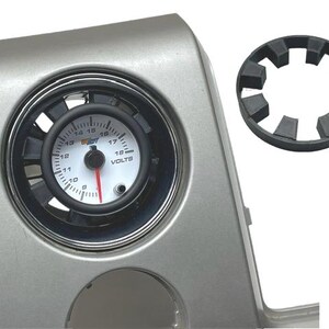 May include: A silver gauge pod with a white face voltmeter gauge reading 16 volts. The gauge has a black bezel and a red needle. A black plastic ring is included.