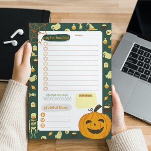 May include: A green and orange Halloween themed to-do list with a pumpkin, ghosts, and other Halloween imagery. The list has space for writing tasks, a reminder section, and a grateful time section.
