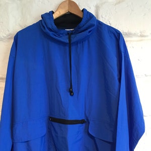 Könnte beinhalten: Eine leuchtend blaue Kapuzenjacke mit Kordelzug und einer Reißverschlusstasche auf der Vorderseite. Die Jacke hat einen gerippten Saum und Bündchen.