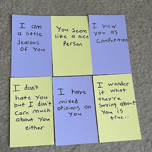 May include: Six rectangular cards in light purple and pale yellow, each featuring handwritten black text. The cards display phrases including I am a little jealous of you, You Seem like a nice Person, I view you as Competition, I don't hate You but I don't Care Much about You either, I have mixed opinions on You, and I wonder if what they're Saying about You is true.