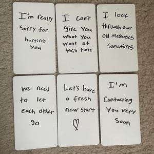 Puede incluir: Seis tarjetas blancas con mensajes escritos a mano. Los mensajes incluyen frases como "Realmente lamento haberte lastimado", "No puedo darte lo que quieres" y "Tengamos un nuevo comienzo".