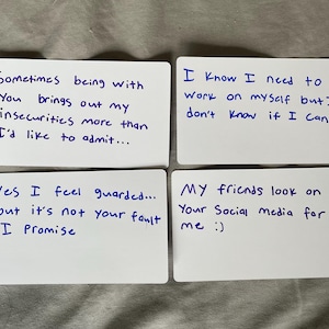 Puede incluir: Cuatro tarjetas blancas con texto azul escrito a mano. Las tarjetas contienen frases como "A veces estar contigo saca a relucir mis inseguridades" y "Sé que necesito trabajar en mí mismo". Las tarjetas están dispuestas sobre una superficie gris.