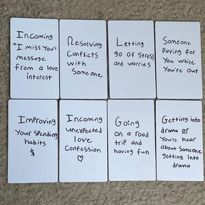 May include: Eight white rectangular cards arranged in two rows, each featuring black handwritten text. The cards display phrases such as Incoming I miss You message, Resolving Conflicts, Letting go of Stress, Someone Paying for You, Improving Your Spending habits, Incoming unexpected love Confession, Going on a road trip, and Getting into drama.