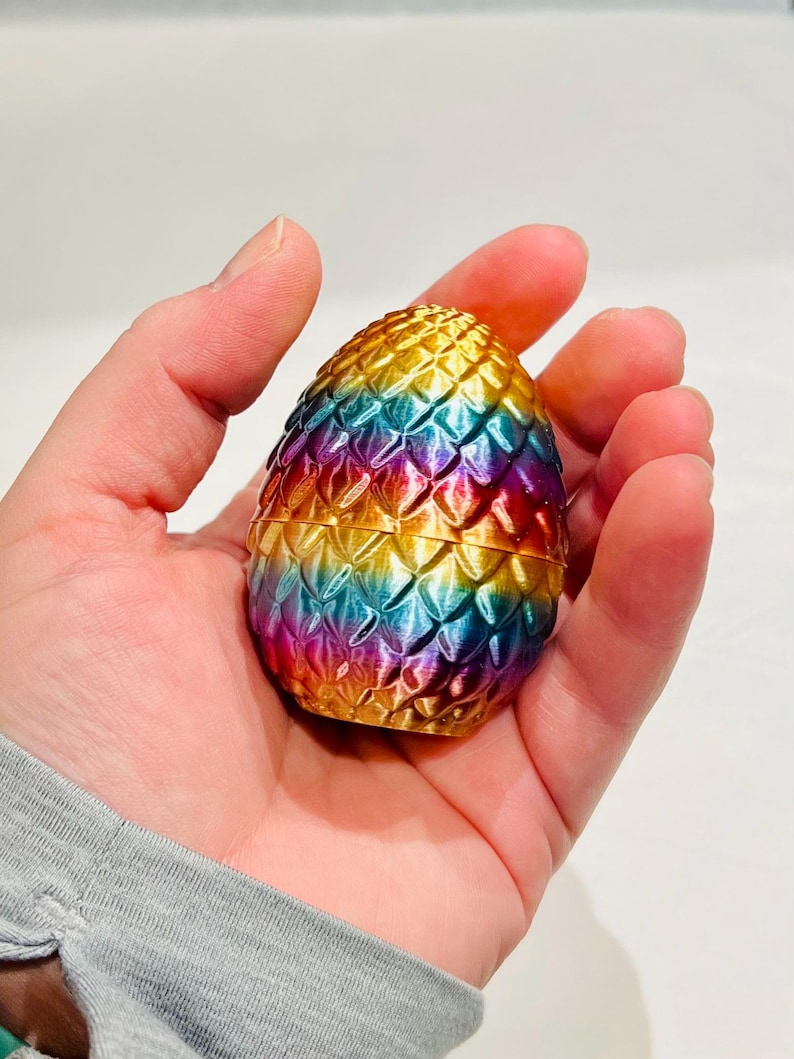 Peut inclure: Un bibelot en forme d'&oelig;uf de dragon aux couleurs de l'arc-en-ciel avec une finition dor&eacute;e. L'&oelig;uf est fait d'un mat&eacute;riau textur&eacute; qui ressemble &agrave; des &eacute;cailles.