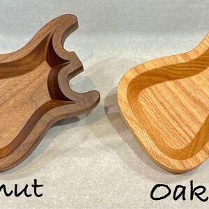 May include: Two wooden guitar-shaped dishes, one made of walnut and one made of oak.