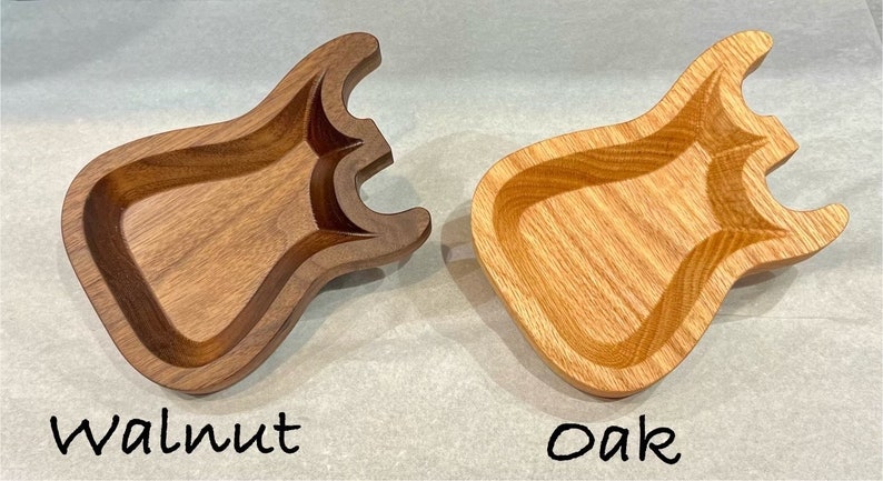May include: Two wooden guitar-shaped dishes, one made of walnut and one made of oak.