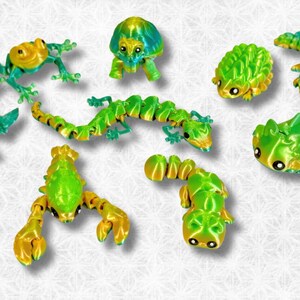 Peut inclure: Une collection de neuf petites figurines d'animaux peintes &agrave; la main, de couleurs vives, comprenant une grenouille, une tortue, un scorpion et un l&eacute;zard. Les figurines sont faites d'un mat&eacute;riau lisse et brillant et pr&eacute;sentent une palette de couleurs vives vert et jaune.