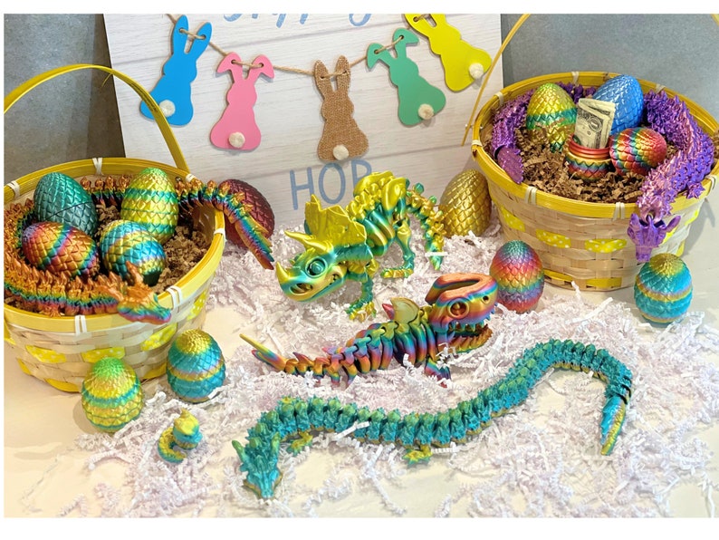 Peut inclure: Une collection d'&oelig;ufs de P&acirc;ques iris&eacute;s dans un panier en osier jaune. Les &oelig;ufs sont d&eacute;cor&eacute;s d'un dragon, d'un dinosaure et d'autres motifs color&eacute;s. Le panier est entour&eacute; de papier blanc d&eacute;chiquet&eacute; et d'une pancarte qui dit "HOP".