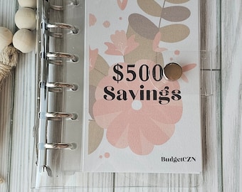 May include: A clear plastic binder with a floral design page that says "$500 Savings" and "BudgetCZN".