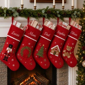Puede incluir: Cinco calcetines navideños rojos con borde festoneado blanco y nombres bordados en letra blanca. Cada calcetín presenta un aplique festivo único: un cascanueces, una corona, un árbol, una casa de jengibre y un oso de peluche.