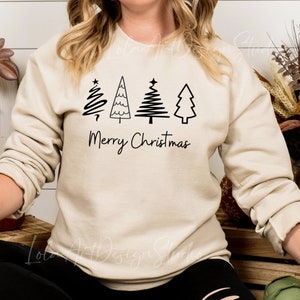 K&ouml;nnte beinhalten: Ein beiger Pullover mit einer schwarzen Grafik von vier stilisierten Weihnachtsb&auml;umen und dem Text "Frohe Weihnachten".