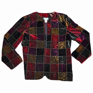Puede incluir: Chaqueta de terciopelo vintage con un diseño de patchwork en tonos rojos, negros, morados y dorados. La chaqueta tiene mangas largas y un diseño sin cuello. Las costuras doradas delinean cada cuadrado del patchwork.