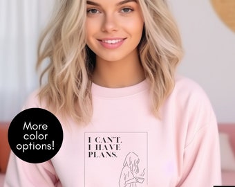 Pode incluir: Uma camisola cor-de-rosa com o texto "I CAN'T. I HAVE PLANS." e um desenho de linha de uma pessoa a segurar uma chávena de café e uma pilha de panquecas.