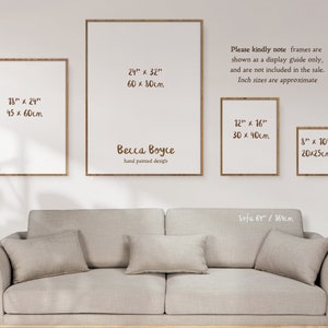 Four frames hung about a sofa in a sunlit room. The four frames are different sizes to show how different print sizes look when framed on a wall. A note reads - frames are shown as a display guide only, and are not included