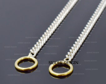 May include: Two silver chains with gold rings at the ends. The chains are curb style and the rings are round.