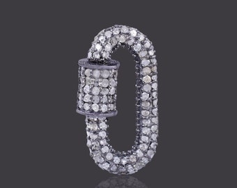 Puede incluir: Un charm ovalado de plata con engaste de diamantes pavé. El charm es de estilo cierre de langosta.