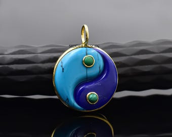 May include: Gold pendant featuring a yin yang symbol with blue and turquoise stones and green accents.