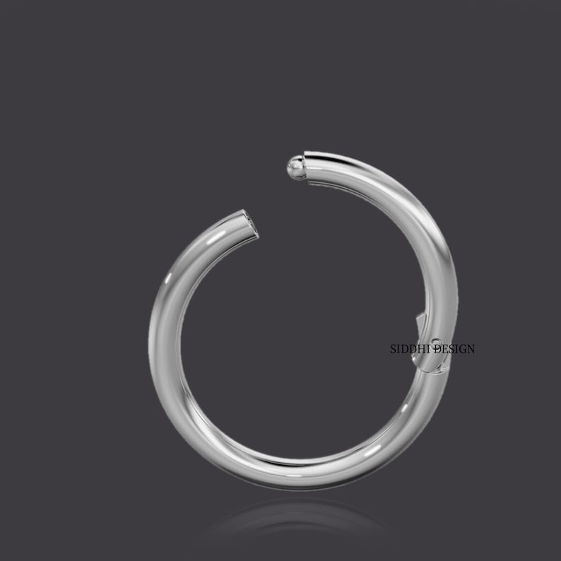 May include: A silver hoop earring with a ball closure. The earring is open and ready to be worn.