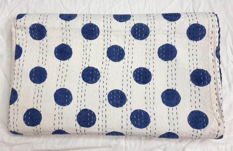 May include: White cotton quilt with a blue polka dot pattern. The quilt is hand-stitched and has a traditional kantha design.