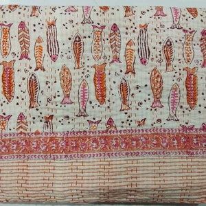 May include: A white cotton quilt with a repeating pattern of orange and pink fish. The quilt has a border of orange and pink floral designs.