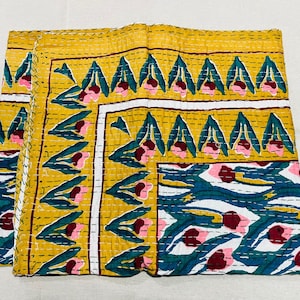 May include: A yellow, white, and blue kantha quilt with a floral pattern. The quilt is made of cotton and is hand-stitched.