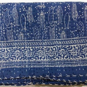 May include: A blue and white kantha quilt with a fish pattern and a floral border. The quilt is made of cotton and is hand-stitched.