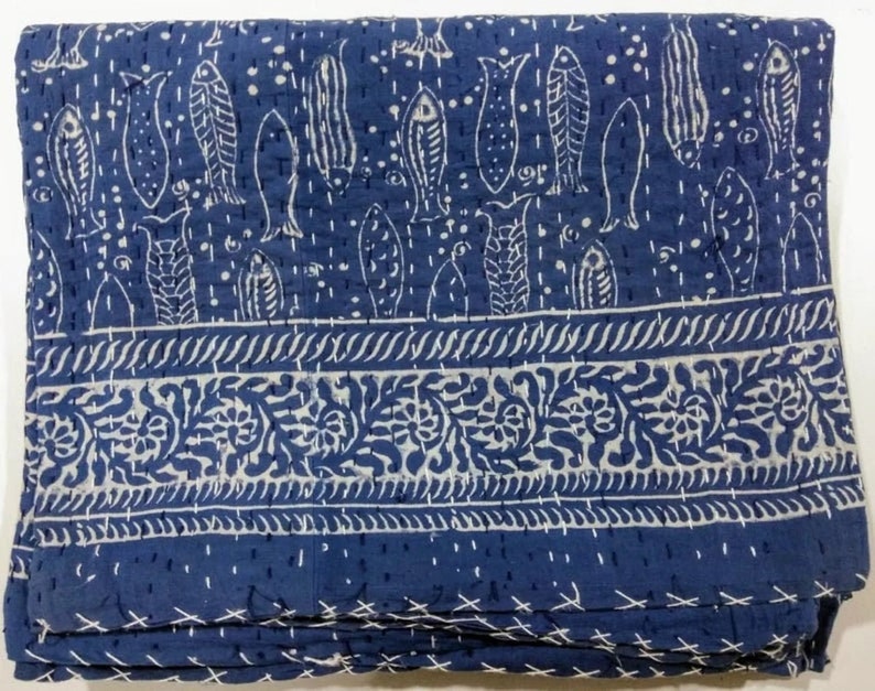 May include: A blue and white kantha quilt with a fish pattern and a floral border. The quilt is made of cotton and is hand-stitched.