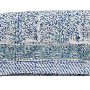 May include: A white cotton quilt with a blue and green floral pattern. The quilt has a border of blue and green stripes.