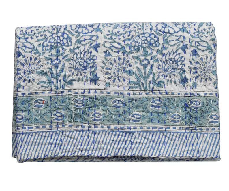 May include: A white cotton quilt with a blue and green floral pattern. The quilt has a border of blue and green stripes.