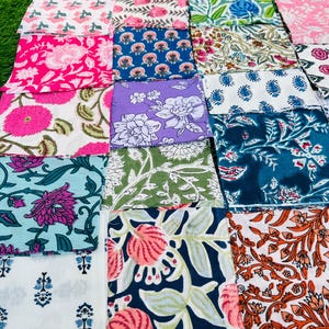 May include: A collection of 16 fabric squares with various floral patterns in shades of pink, blue, green, and white. The fabric squares are arranged in a grid pattern.