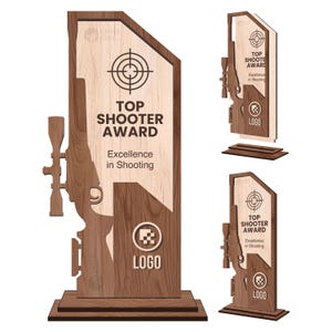 Puede incluir: Trofeo de madera "Top Shooter Award" con una silueta de rifle y un gráfico de diana. El trofeo presenta el texto "Top Shooter Award" y "Excellence in Shooting". Incluye un logotipo en la parte inferior. El trofeo es de madera marrón clara y oscura.