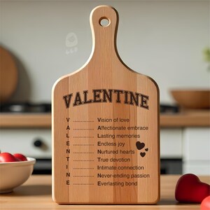 May include: A wooden cutting board with a handle, engraved with the word "VALENTINE" and a list of romantic sentiments. The board is light brown with a smooth finish, perfect for kitchen decor or a thoughtful gift.