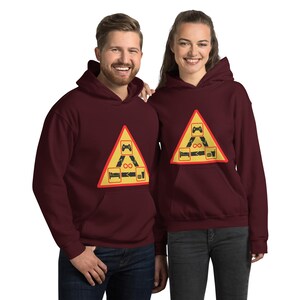 Könnte beinhalten: Zwei weinrote Hoodies mit einem gelben Warnschild in Dreiecksform. Das Schild zeigt einen Videospielcontroller, ein Bett, ein Unendlichkeitszeichen und ein Glas Flüssigkeit. Der Text auf dem Schild lautet "Gefahr: Gamer Zone".