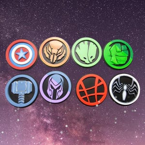 Könnte beinhalten: Acht runde, farbige, bedruckte Untersetzer mit Superhelden-Logos. Die Logos beinhalten Captain America, Hulk, Iron Man, Thor, Venom, Groot, Magneto und Doctor Strange.
