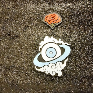 May include: A white eye with a blue iris and pupil surrounded by a blue ring and white clouds on a black background.