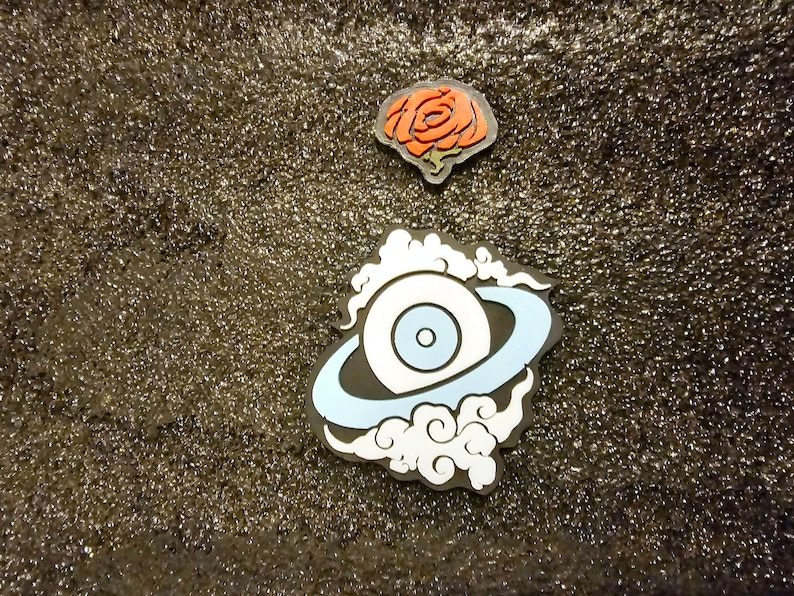 May include: A white eye with a blue iris and pupil surrounded by a blue ring and white clouds on a black background.