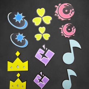 May include: A set of 10 colourful iron-on patches featuring various designs, including a crown, a musical note, a clover, a star, and a swirl. The patches are perfect for adding a unique touch to clothing, bags, or other accessories.