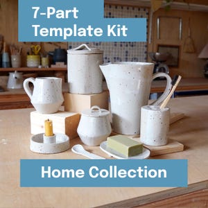 Op de afbeelding: Een 7-delige Template Kit Home Collection. De afbeelding toont een verzameling gespikkelde witte keramische items, waaronder een kan, een mok, een pot, een zeepbakje en een kandelaar. De tekst "Home Collection" wordt onderaan weergegeven.