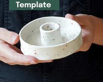 Könnte beinhalten: Ein weißer Kerzenhalter aus Keramik mit braunen Sprenkeln und einem zentralen Zylinder. Der Halter ist rund und wird in den Händen einer Person gehalten. Der Text "Printable Template" befindet sich in einem grünen Rechteck im Hintergrund.