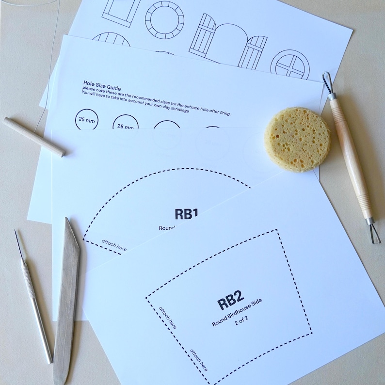 Pu&ograve; includere: Una collezione di strumenti artigianali e modelli stampati per progetti di ceramica. Include una spugna, strumenti in legno e modelli di carta con linee tratteggiate e testo, tra cui "RB1" e "RB2 Round Birdhouse Side".