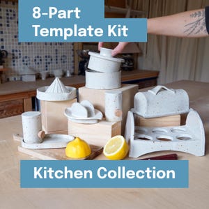Pode incluir: Um kit de modelos de 8 peças da Coleção Kitchen. O kit inclui várias ferramentas de cozinha de cerâmica salpicada, como um espremedor, uma manteigueira e um porta-ovos. Um limão é cortado ao meio e o texto "Kitchen Collection" é exibido.
